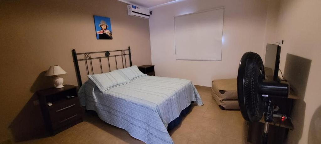 a bedroom with a bed and a dresser and a fan at Dúplex amplio y luminoso in San Fernando del Valle de Catamarca
