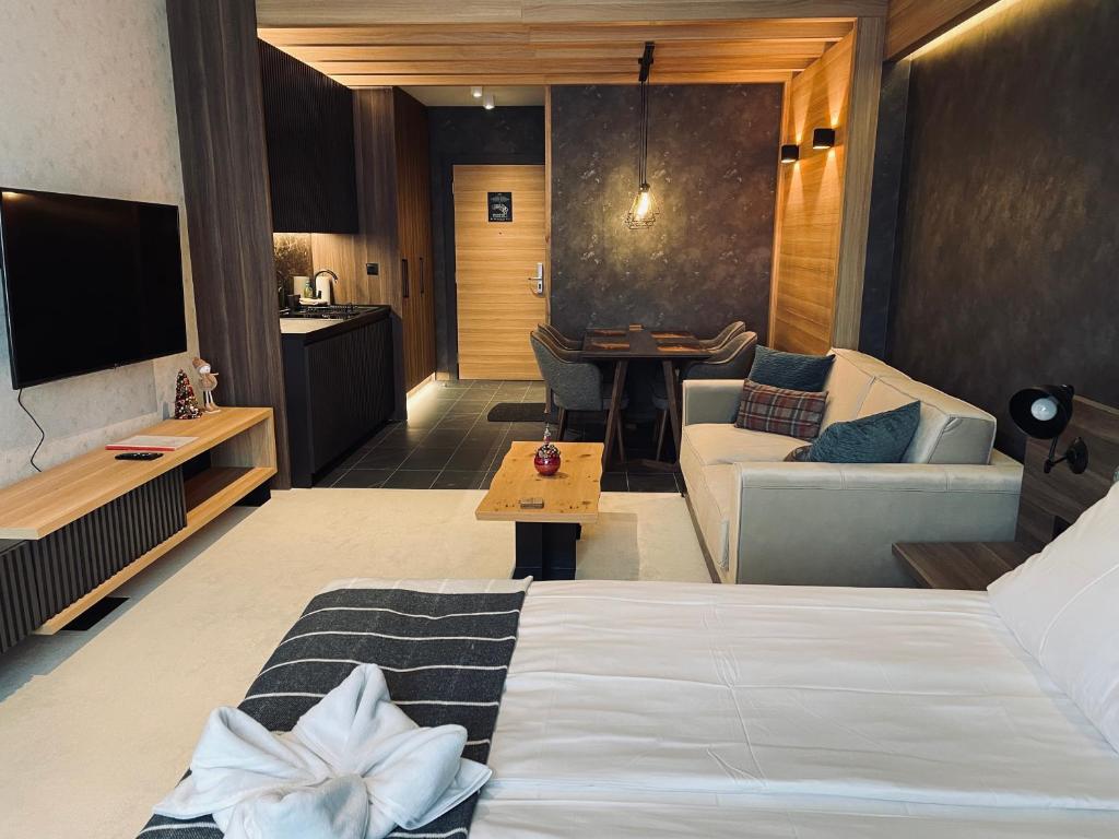 a hotel room with a bed and a living room at Woodside Apartman Kopaonik 315 in Kopaonik