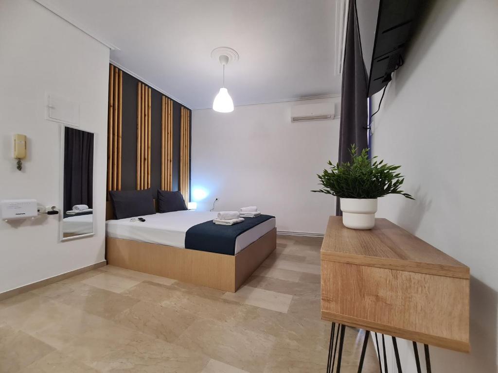 - une chambre avec un lit et une plante en pot dans l'établissement Apartment in the heart of the city 5Β, à Larissa