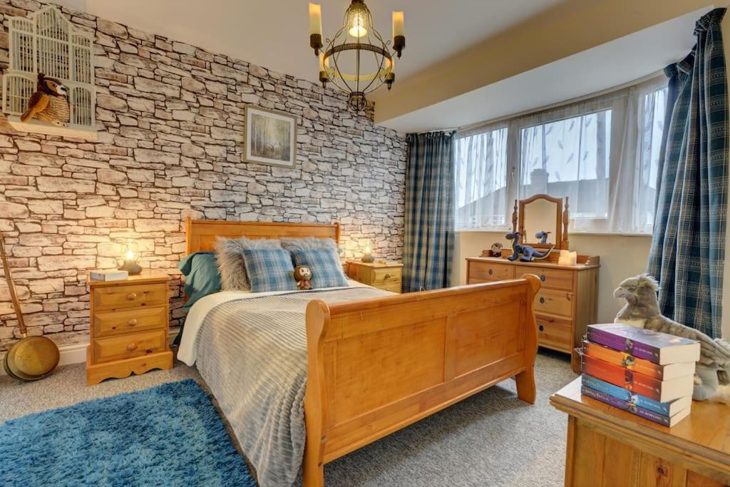 a bedroom with a bed and a brick wall at Hagrid's Hut in Watford
