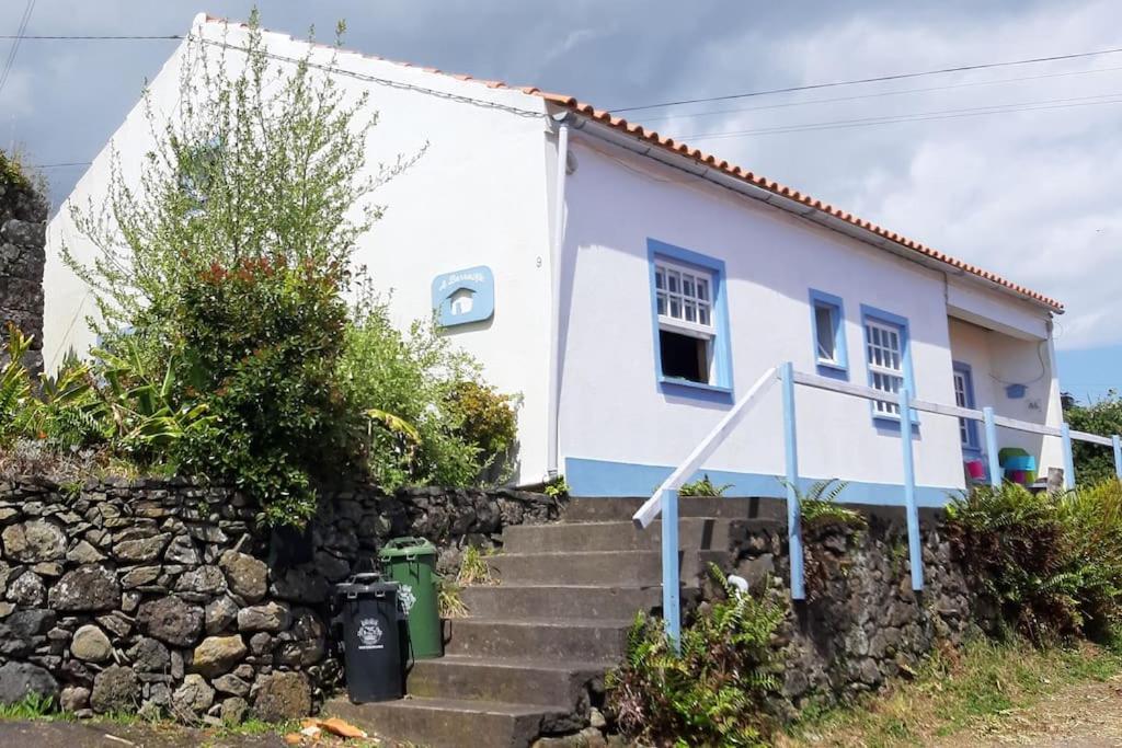 uma casa branca com escadas em frente em A Barraka: your cozy house in Flores! em Lajes das Flores