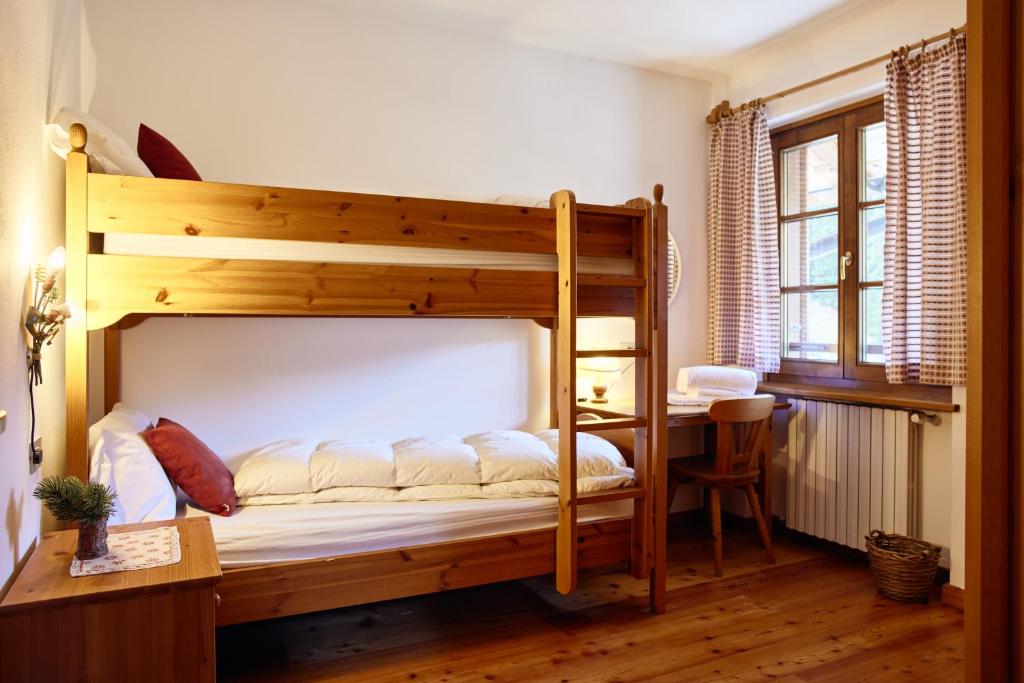 - une chambre avec des lits superposés et un bureau dans l'établissement Rifugio Malga Ra Stua, à Cortina dʼAmpezzo