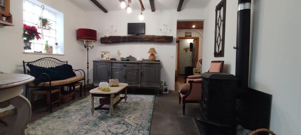 Casa Odélia في المارجيم: غرفة معيشة مع تلفزيون وطاولة وكراسي