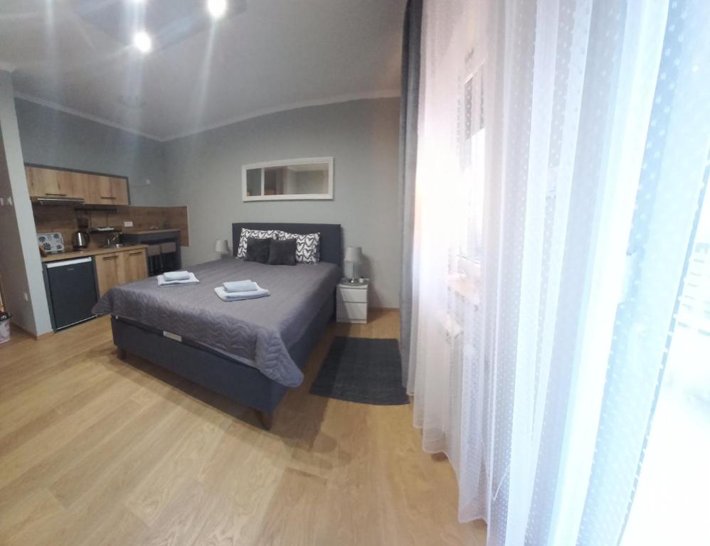 a small bedroom with a bed and a kitchen at Apartman Lola in Subotica