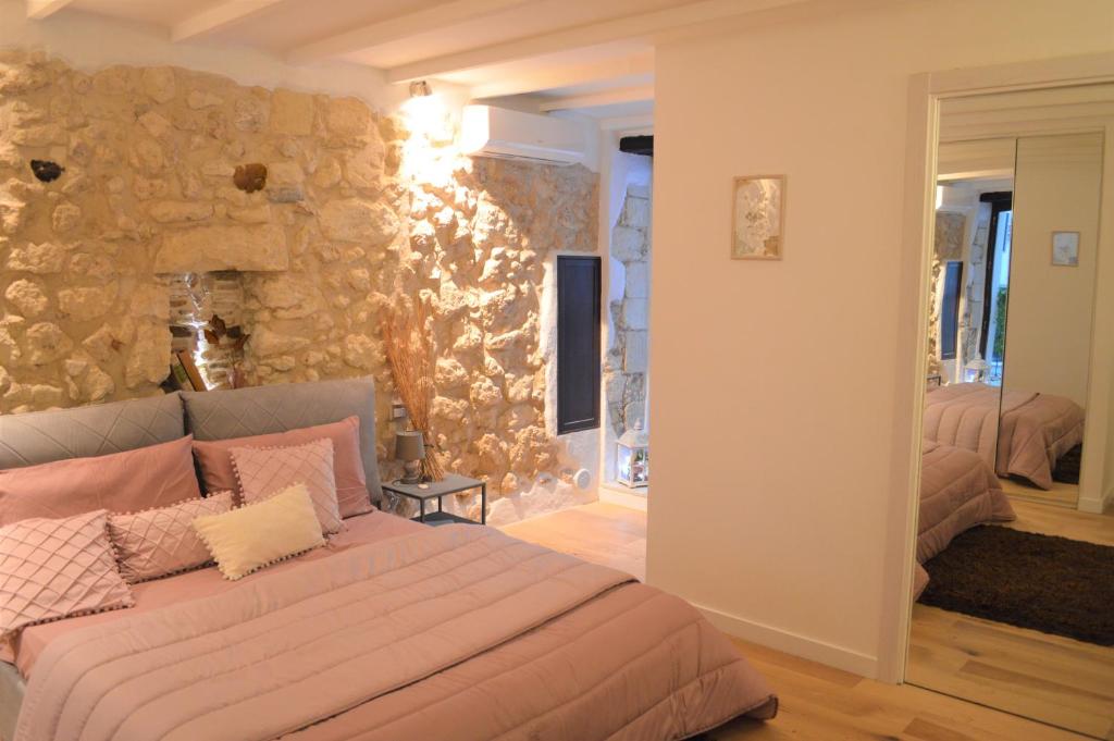 una camera con letto e parete in pietra di Domu 600 - Suite mini appartamento Cagliari centro storico a Cagliari