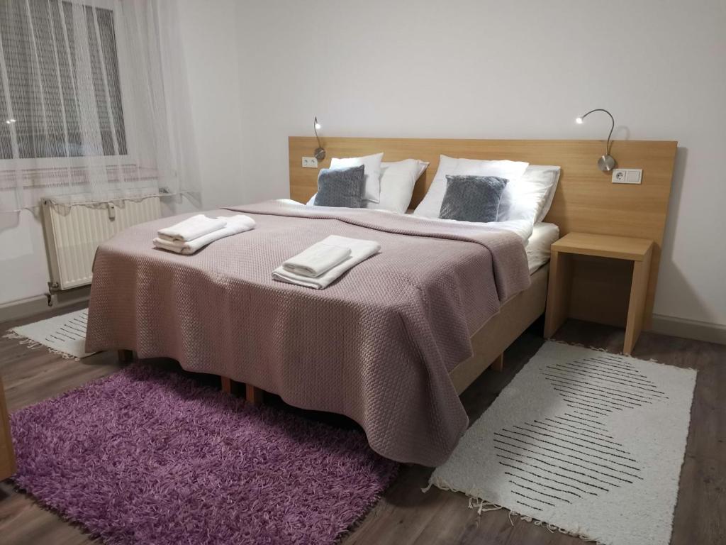 a bedroom with a large bed with a purple rug at Eisenerzer Apartmenthaus in Eisenerz