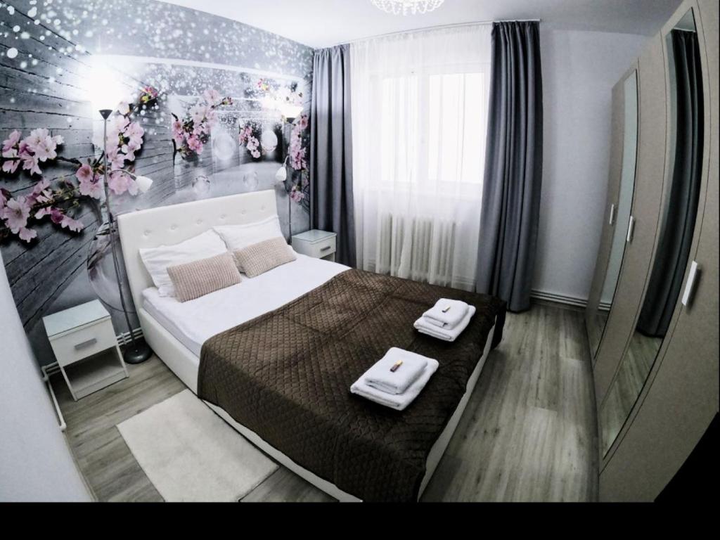 a bedroom with a bed with two towels on it at New York Apartament in Suceava