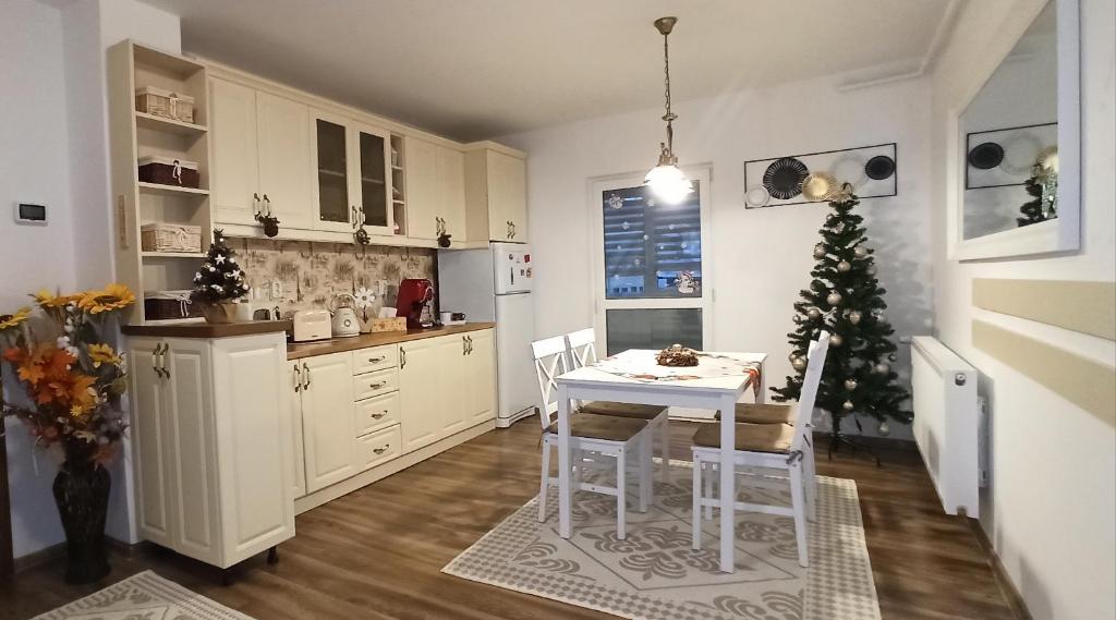 彼得羅沙尼的住宿－Apartament Atena，厨房配有桌子和圣诞树