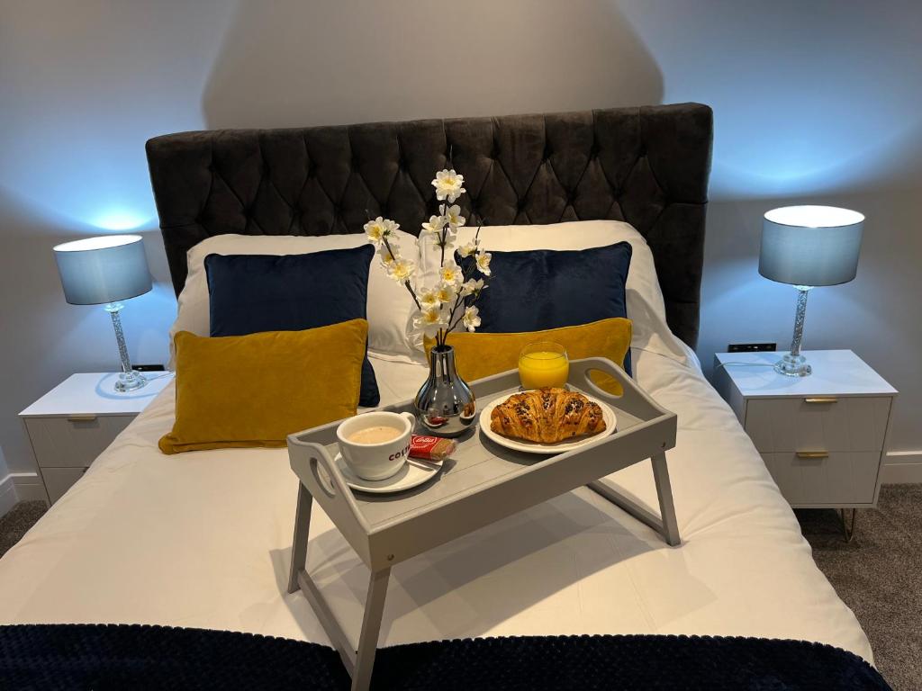 uma cama com uma bandeja de comida numa mesa em The Penthouse - Luxury 2 Bed Apartment em Skegness