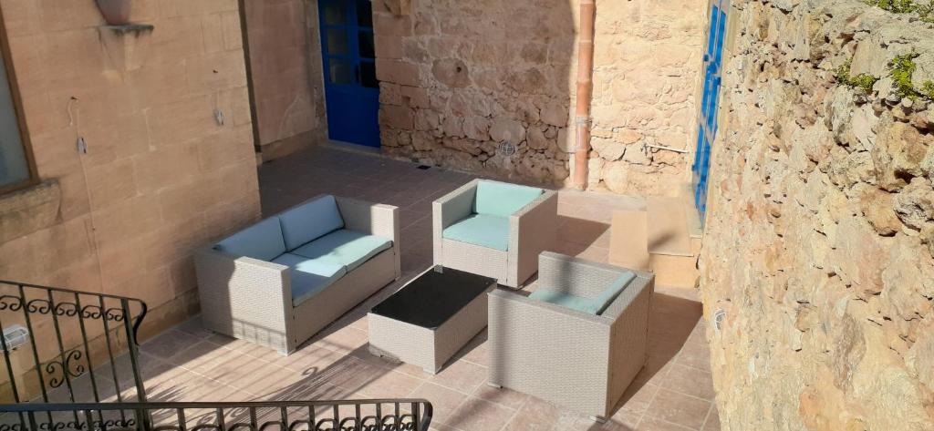 a group of chairs and tables on a patio at Ta’ Peppi Farmhouse in Qala