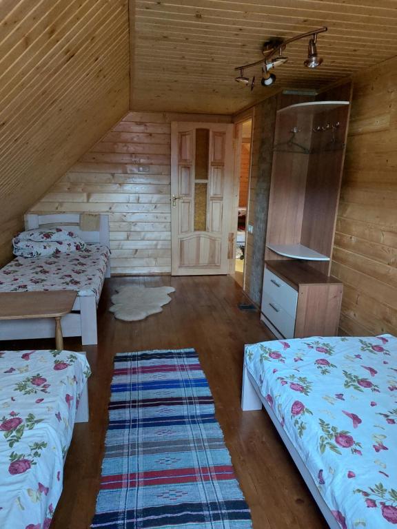 pokój z 3 łóżkami w drewnianym domku w obiekcie Садиба Під Чертежиком w mieście Kolochava