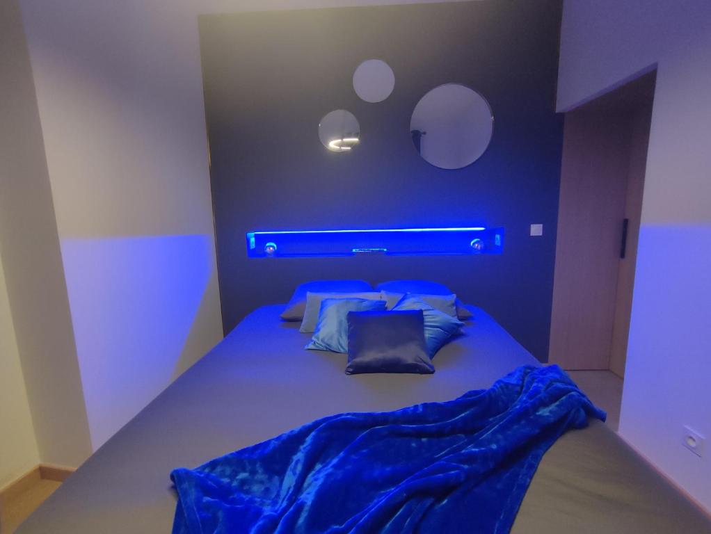 een slaapkamer met een bed met een blauw licht erop bij Cocon Lux au centre de Voiron in Voiron