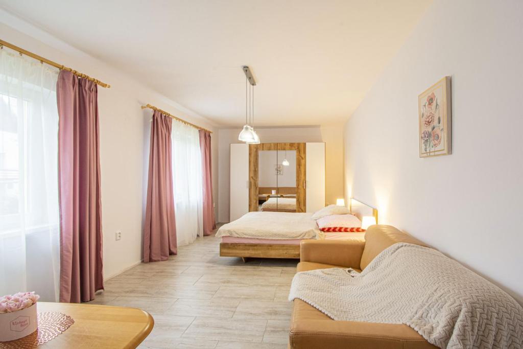 a living room with a couch and a bed at Velký apartmán Zlámanka in Kroměříž