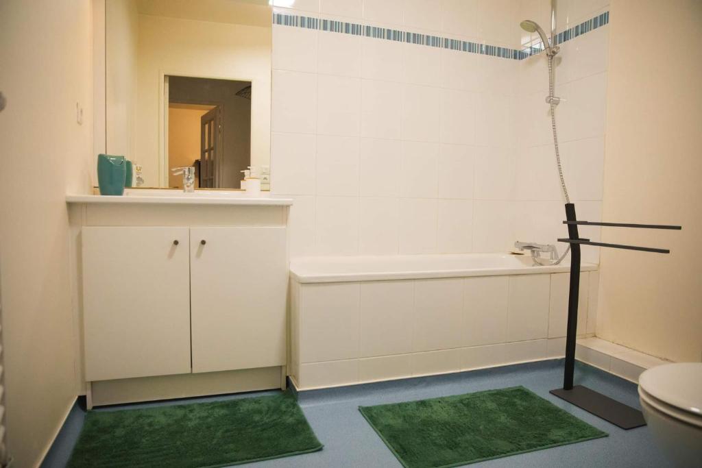 La salle de bains est pourvue d'une baignoire, d'un lavabo et de toilettes. dans l'établissement Au Reflet Du Pont, à La Rivière-Saint-Sauveur