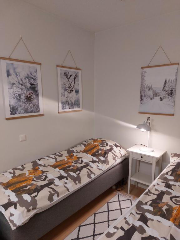 um quarto com uma cama e uma mesa de cabeceira com uma cama sidx sidx em Nordic Home, with private sauna em Rovaniemi