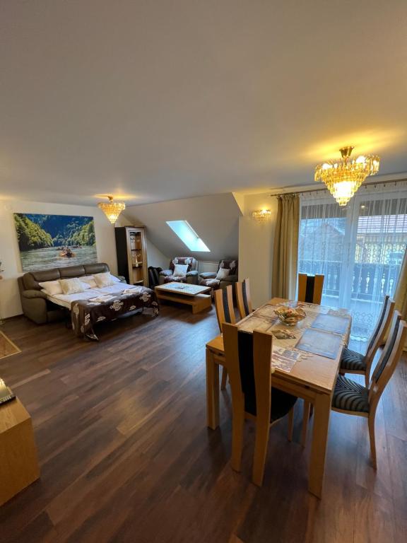 a dining room and living room with a table and chairs at Apartament Pieniny Dream in Krościenko