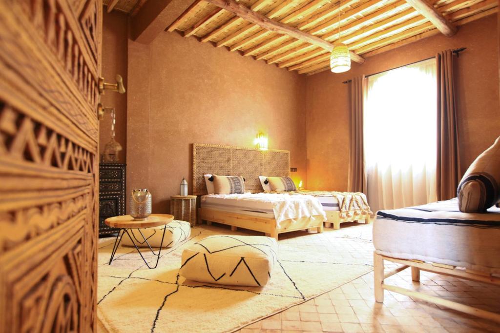 a bedroom with two beds and a large window at Riad Dar Tiziri in Zagora