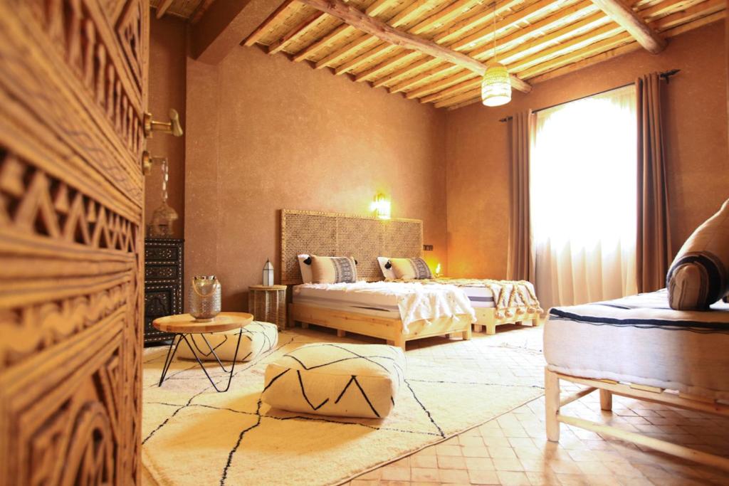 um quarto com 2 camas e uma grande janela em Riad Dar Tiziri em Zagora