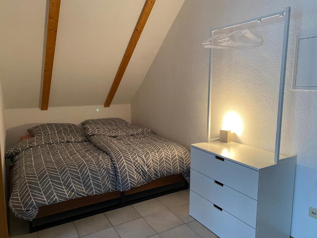 a small bedroom with a bed and a dresser at FEWO Eggenstein beim KIT in Eggenstein-Leopoldshafen