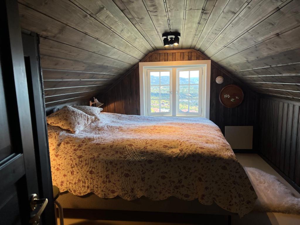 een slaapkamer met een groot bed en een raam bij Fin leilighet med flott beliggenhet ski in ski out in Beitostøl