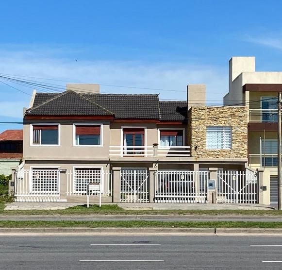 una casa con una valla blanca frente a una calle en ROMA apartamento frente al mar en Mar del Plata