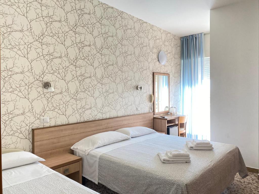 una camera con 2 letti e un murale di Hotel Ravello a Rimini