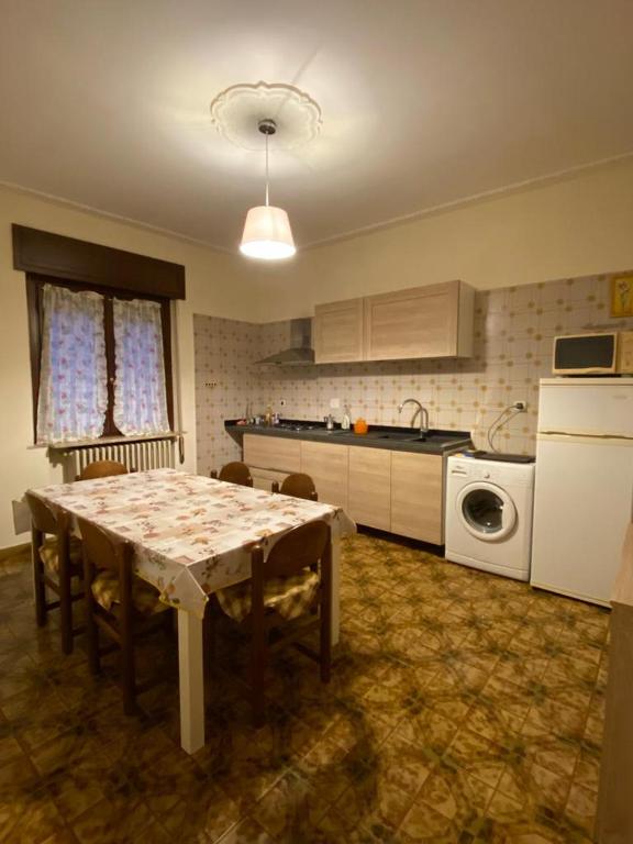 a kitchen with a table and a kitchen with a washing machine at Casa Andrea in Ghedi