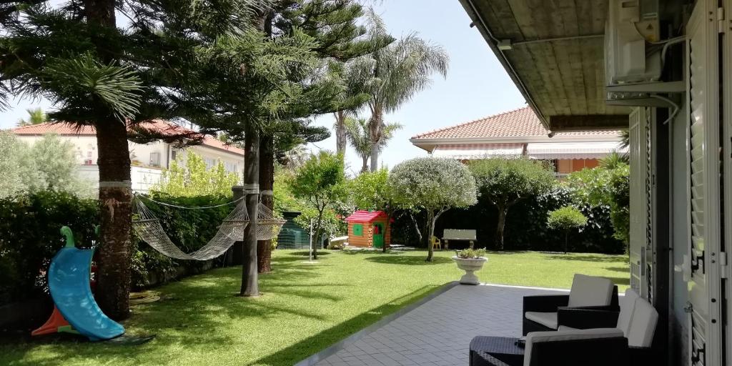 a backyard with a hammock hanging from a tree at Casa Michelangela in Mascali