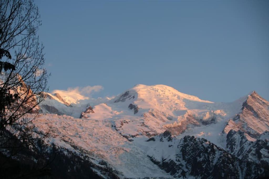 une montagne recouverte de neige avec le soleil brillant sur elle dans l'établissement Three Bedroomed Chalet Apartment, à Chamonix-Mont-Blanc