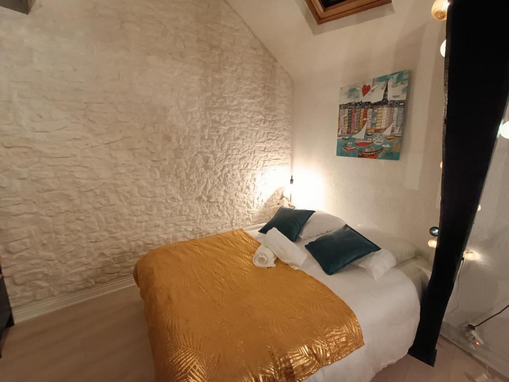 - une chambre avec un lit doté d'un couvre-lit doré dans l'établissement Le cœur du centre historique refait à neuf, à Honfleur