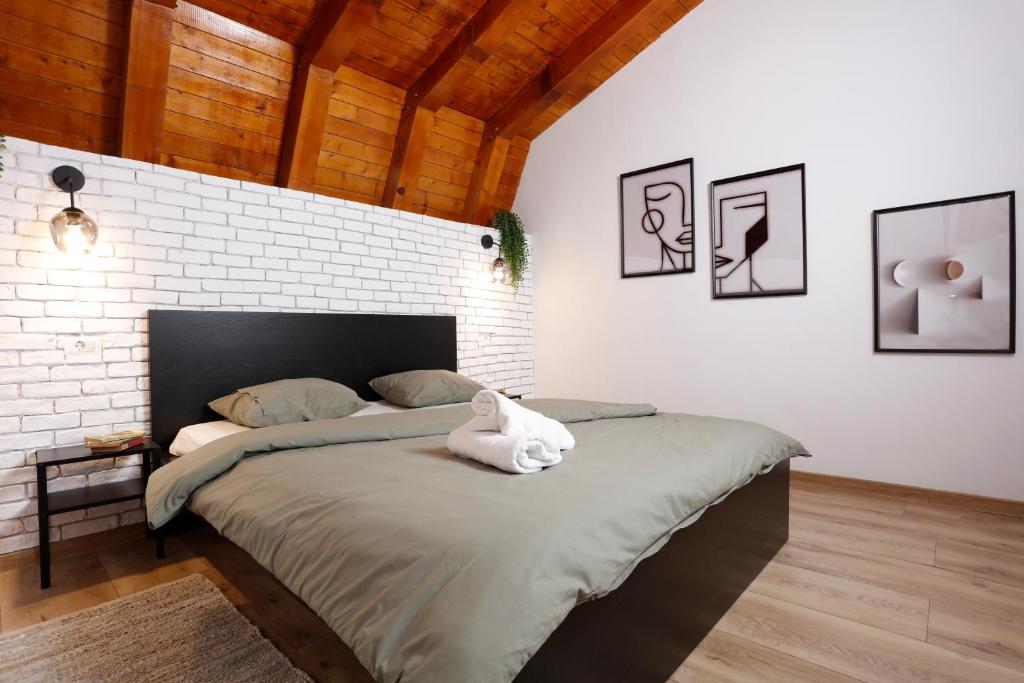 una camera da letto con un letto grande con un muro di mattoni di One Love Central Cottage a Bucarest