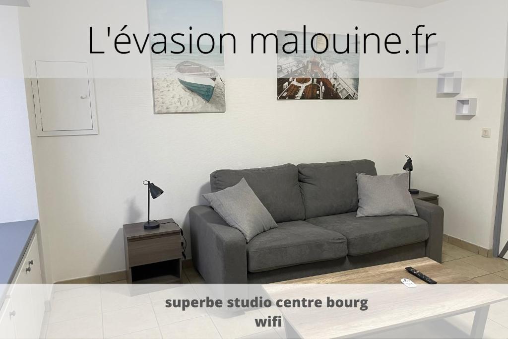 a living room with a couch and a table at Studio 2 personnes en centre ville in Saint-Pierre-de-Plesguen