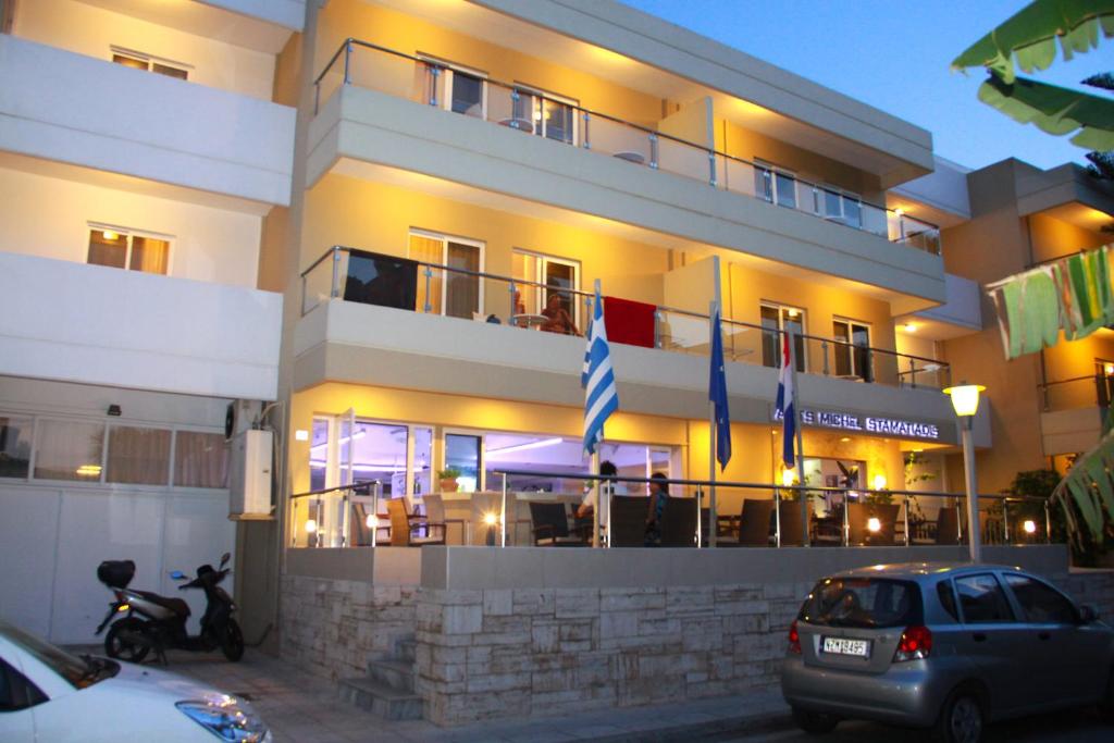 een gebouw waar auto's voor geparkeerd staan bij Michel Apartments in Kos-stad