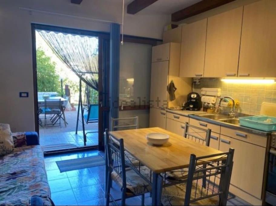 uma cozinha com uma mesa e uma cozinha com um pátio em The Little Lemon Tree em Lu Razzoni