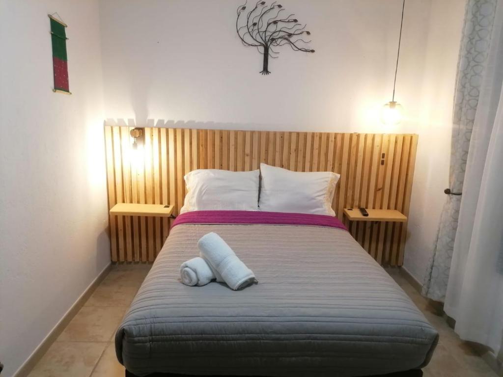 a bedroom with a bed with two pillows on it at Casa Lomas Grangelo in Atlixco