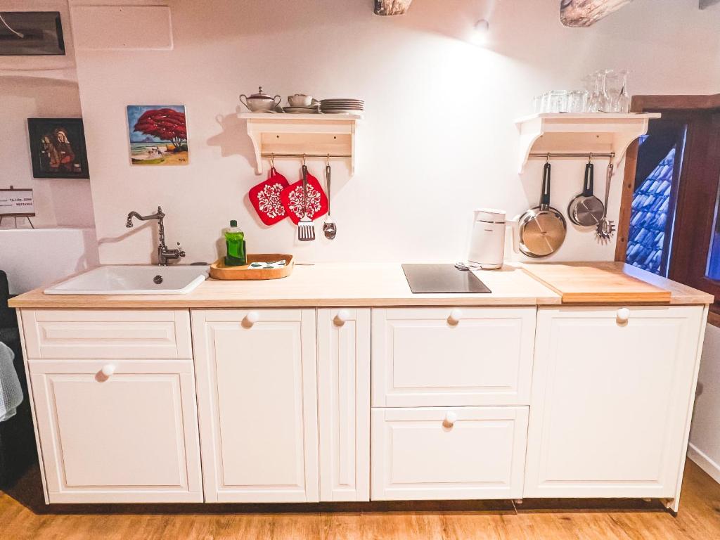 a kitchen with white cabinets and a sink at Holy View Apartment in Bolzano