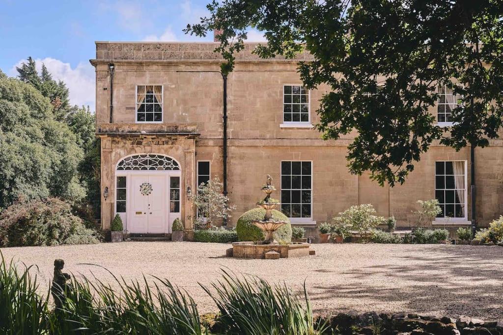 a large brick building with a fountain in front of it at The Manor Holcombe Luxury House Pool & Hot-tub in Holcombe