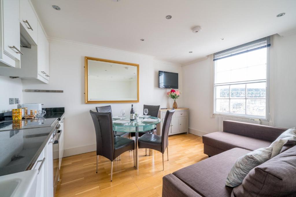 uma cozinha e sala de estar com uma mesa e um sofá em Camden Town Apartment em Londres