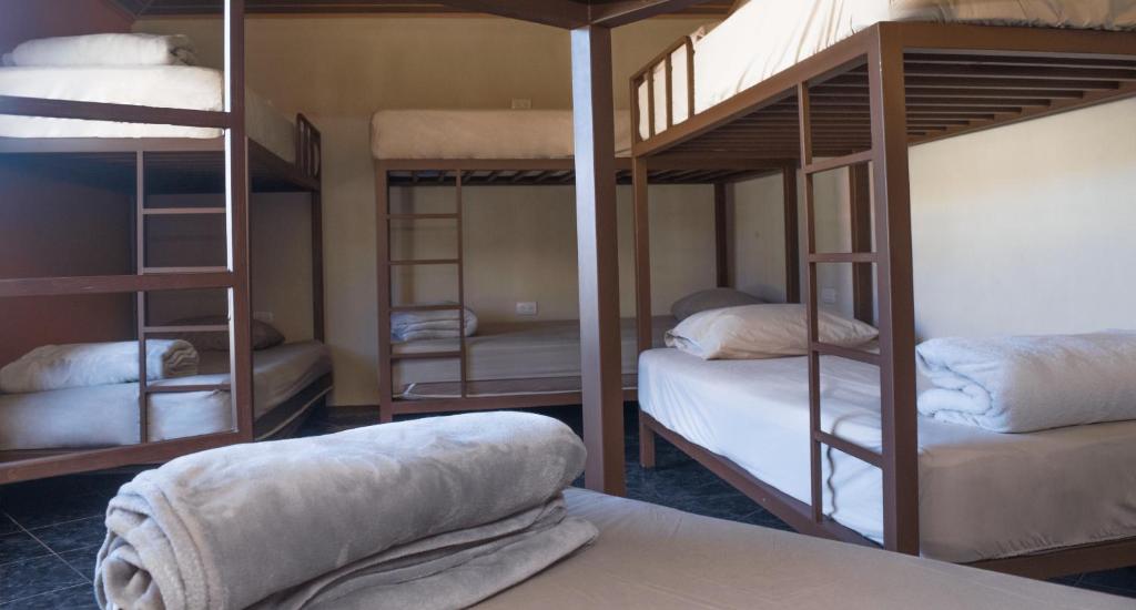 a room with three bunk beds and a bed at Arenal Family House in Fortuna