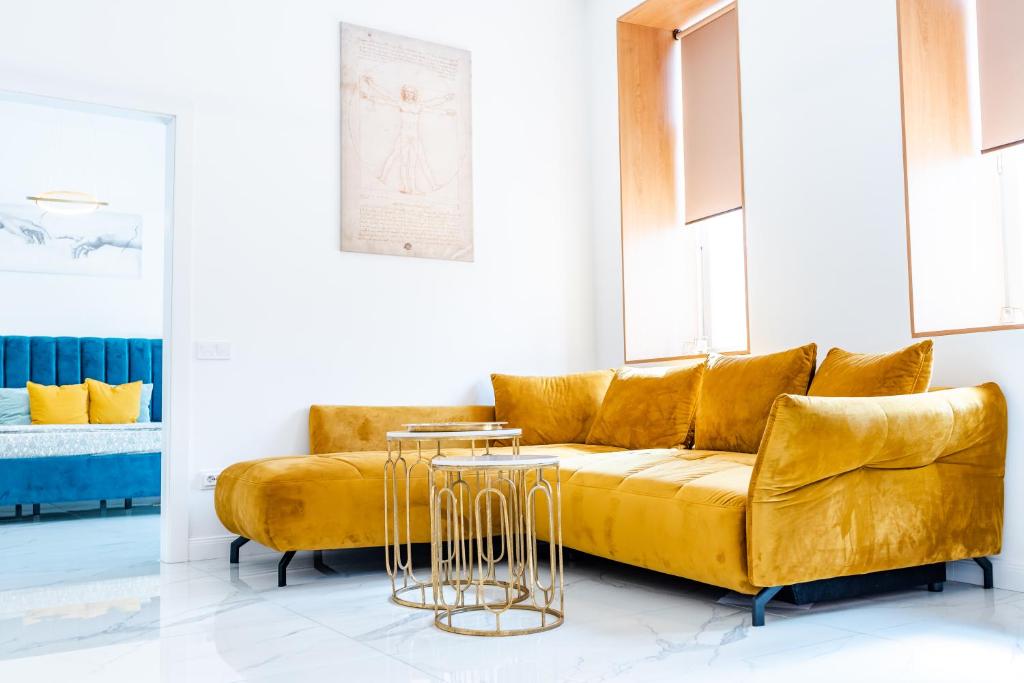 ein Wohnzimmer mit einem gelben Sofa und einem Tisch in der Unterkunft Thome Exclusive Cuvee Turda in Turda