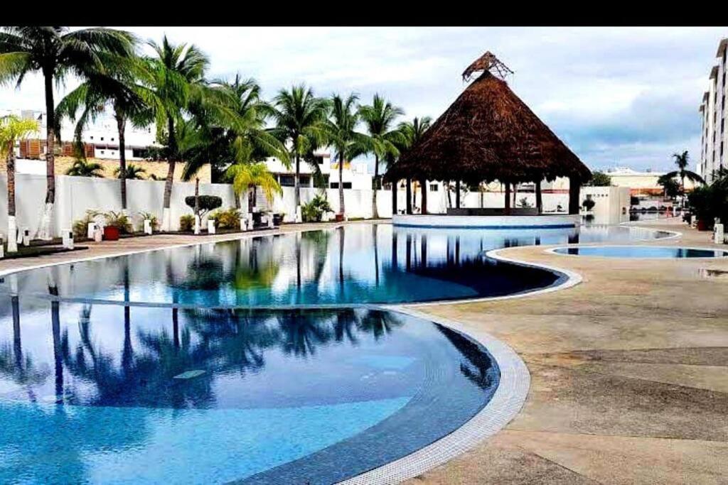 una gran piscina con cenador y palmeras en Departamento de dos habitaciones con increíble alberca y amenidades Y-406 en Cancún
