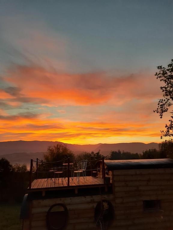 eine Terrasse mit Blick auf die Berge bei Sonnenuntergang in der Unterkunft La petite maison dans la prairie 
