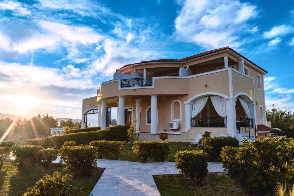 a villa with a garden in front of a building at Anagenessis Resort in Kalamaki