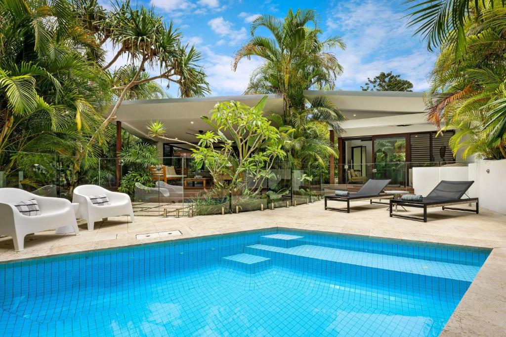 a villa with a swimming pool and a house at Pavilion 5 in Byron Bay