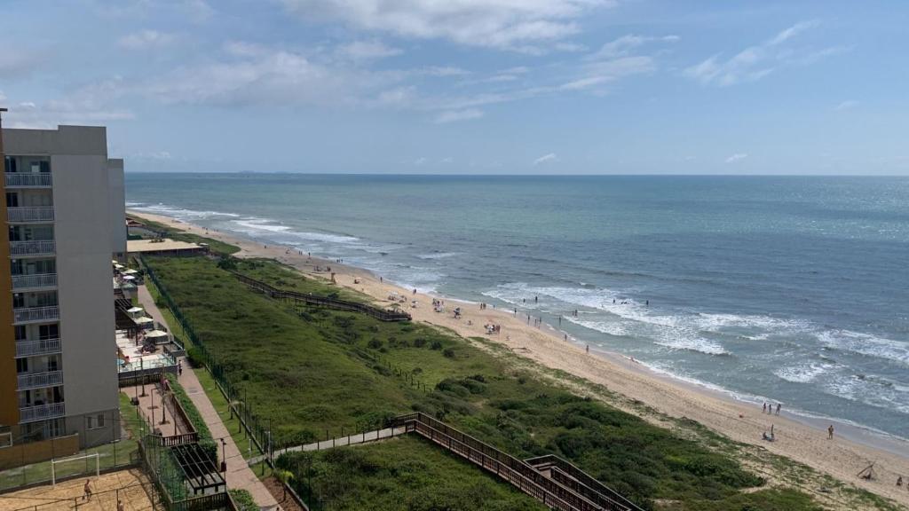 a view of a beach and the ocean with a building at Apto beira-mar pé na areia in Barra Velha