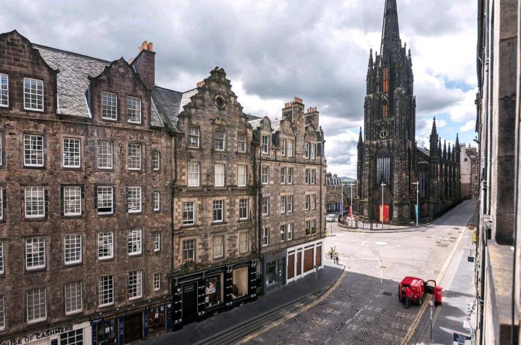 a view of a city street with buildings and a church at Unique 2 Bedroom Castle Suite Apartment - Near Edinburgh Castle & Royal Mile in Edinburgh