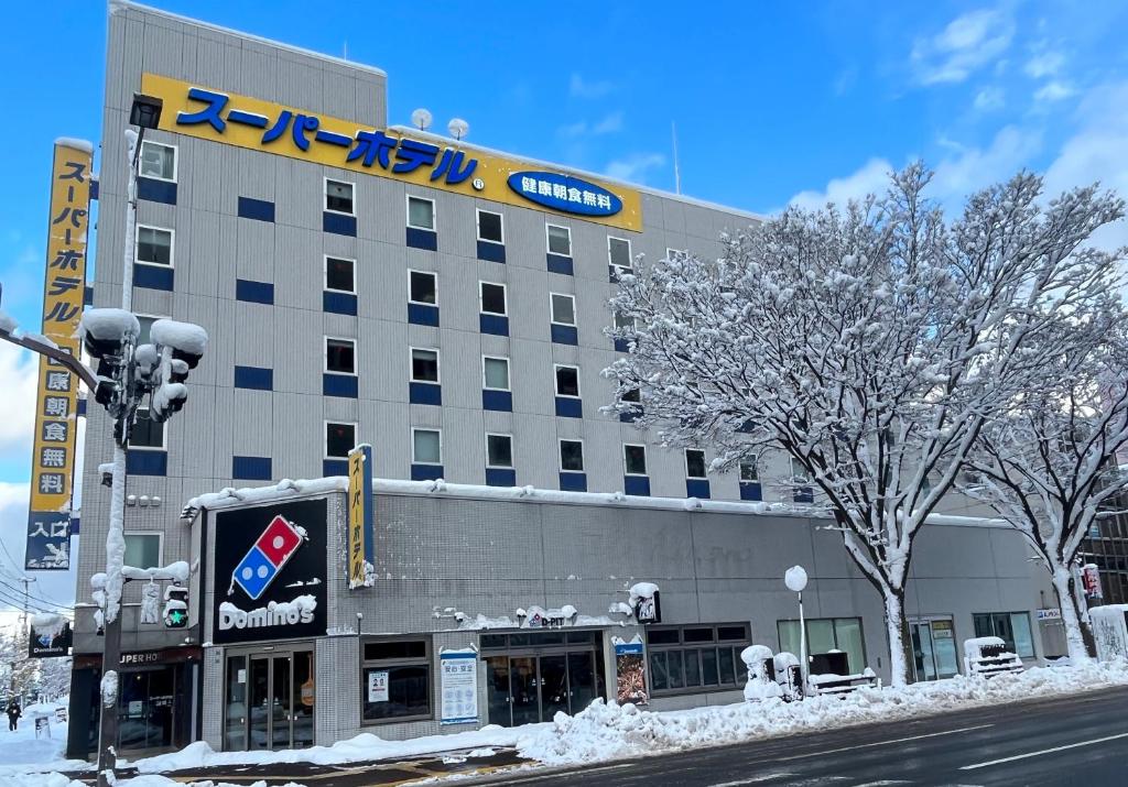 a building with a sign on top of it at Super Hotel Aomori in Aomori