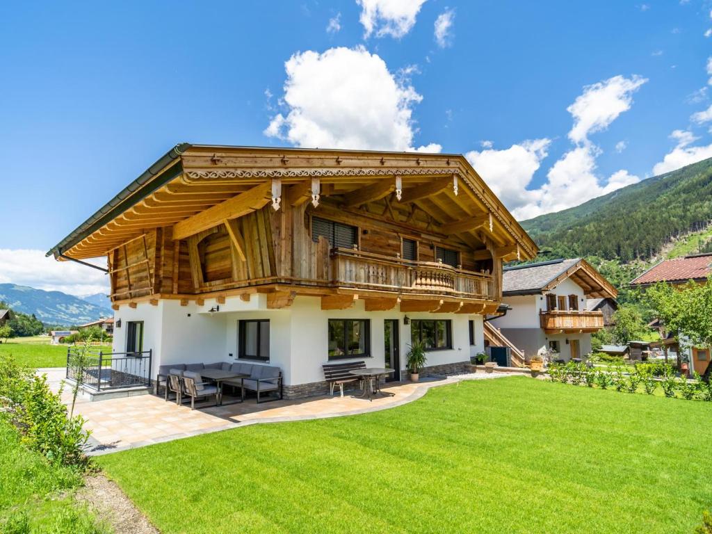 a large wooden house with a large yard at Chalet Bodahof in Aschau