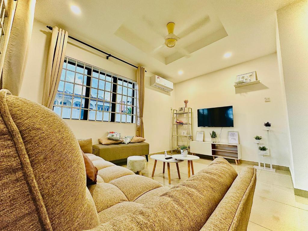 a living room with a couch and a tv at Ipoh Deluxe Family Home in Ipoh