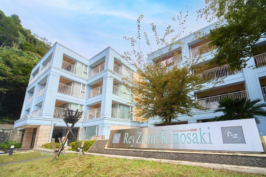 un edificio blanco con un cartel delante en Reyzenit Kinosaki Suite VILLA, en Toyooka